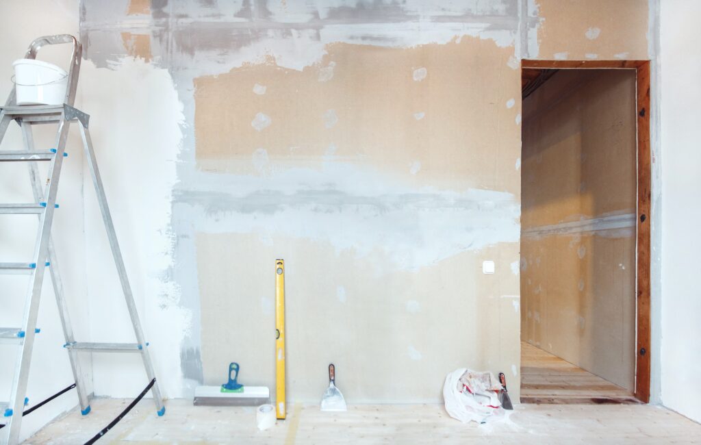 A stepladder with painting tools in a room. Preparing for putty